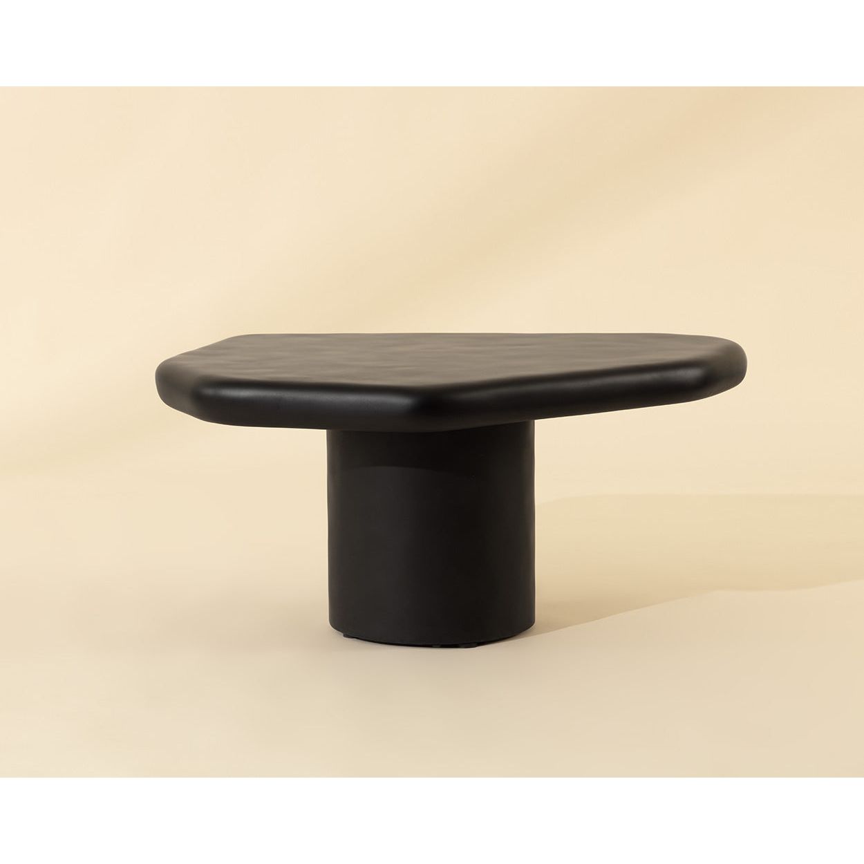 Table basse d'extérieur contemporaine en béton noir, avec une forme géométrique compacte, idéale pour un balcon.