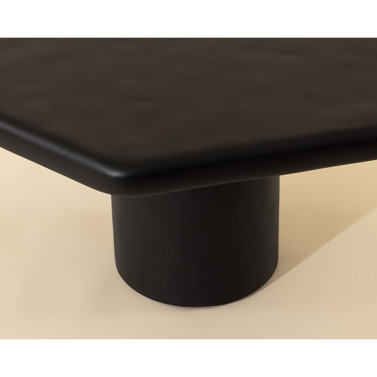 Table basse d'extérieur contemporaine en béton noir, avec une forme géométrique compacte, idéale pour un balcon.